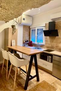 a kitchen with a wooden table and chairs in it at Casa Cueva Transmina 10 in Setenil