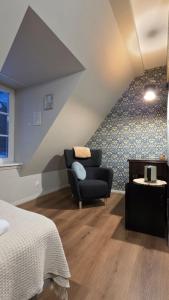 a bedroom with a bed and a chair in a room at Dawno Temu - Agroturystyka Premium in Lipowy Most