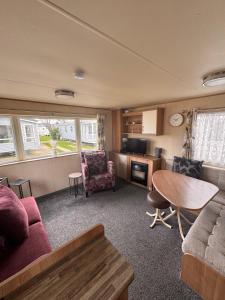 a living room with a couch and a table at Rubys Place on Lyons Winkups Towyn Sleeps 6 in Abergele