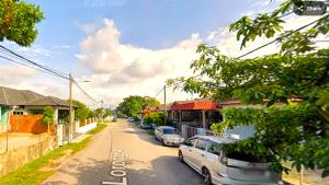 a street with cars parked on the side of the road at A K Homestay in Sungai Petani