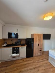 a kitchen with a black refrigerator and white cabinets at Apartment mit Küche in Schwäbisch Hall