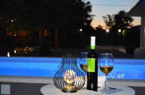 a table with a bottle of wine and two glasses at Villa Ika in Gomila