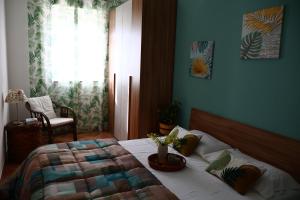 a bedroom with a bed and a chair and a window at Casa Luce in Caltabellotta