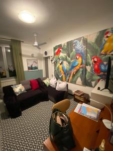 a living room with a couch and a painting of parrots at A4 in Savona