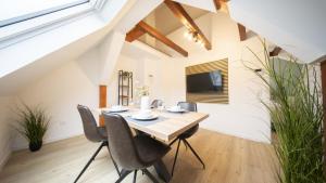 a dining room with a wooden table and chairs at CharmÖHR Homes in Öhringen