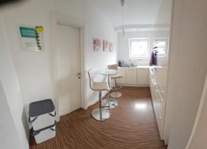 a small white kitchen with a table and chairs at Appartement July in Innsbruck