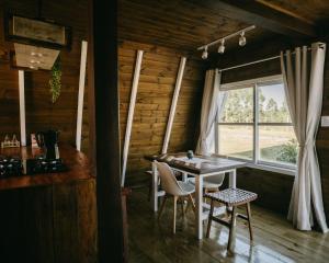 a dining room with a table and chairs and a window at Refúgio Fortaleza - Cabana Physalis in Cambará