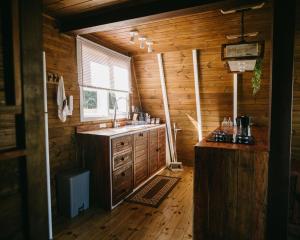 a kitchen with a sink and a window in a log cabin at Refúgio Fortaleza - Cabana Physalis in Cambará +36 photos
