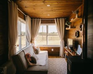a living room with a couch and a window at Refúgio Fortaleza - Cabana Physalis in Cambará