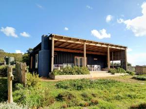 a black house with a wooden roof at Countryside Container Home in Baardskeerdersbos +11 photos