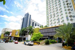 a city street with a tall building and cars at Budget Friendly Centrio Tower Studio Unit PoolView in Cagayan de Oro