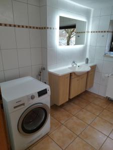 ein Badezimmer mit Waschmaschine und Waschbecken in der Unterkunft Oma‘s Häuschen in Schwenningen + 3 Fotos