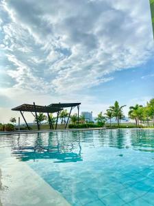 a large swimming pool with a pergola and palm trees at Budget Friendly Centrio Tower Studio Unit PoolView in Cagayan de Oro