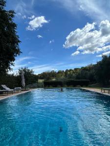 a large pool with blue water in a park at Casale delle Querce in Amelia +11 photos