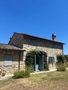 an old stone house with a blue door and ivy at Casale delle Querce in Amelia