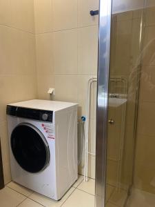 a washing machine in a bathroom with a shower at Cozy Garden Apartment Near Krakow - Free Parking in Gaj +16 photos