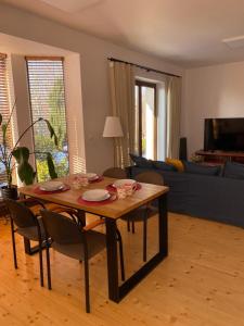 a living room with a wooden table and chairs at Cozy Garden Apartment Near Krakow - Free Parking in Gaj