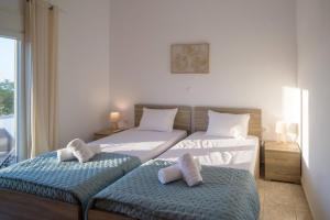 a bedroom with two beds with towels on them at Arezina's Apartment in Vromolithos