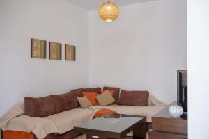 a living room with a brown couch and a table at Arezina's Apartment in Vromolithos