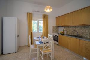 a kitchen with a table and chairs in a kitchen at Arezina's Apartment in Vromolithos