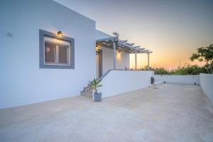 a white building with a tennis court on it at Arezina's Apartment in Vromolithos +5 photos