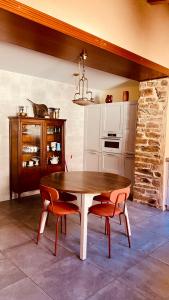 a kitchen with a wooden table and two chairs at La Bodega de la Valduerna 2 in Destriana
