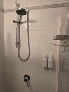 a shower in a bathroom with two bottles of soap at Alloggio turistico Dedicato in Gaeta +39 photos