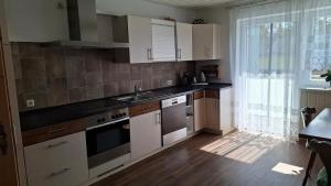 a kitchen with white cabinets and a sink and a window at Uschi's guest apartment in Ruderting