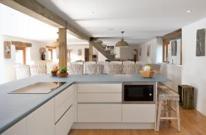 a kitchen with white cabinets and a blue counter top at The Vineyard in Fowey
