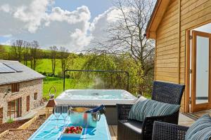 a hot tub on a patio with a table at The Vineyard in Fowey
