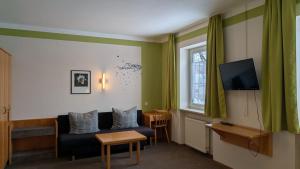 a living room with a couch and a television at Gasthof Postgarten in Furth im Wald
