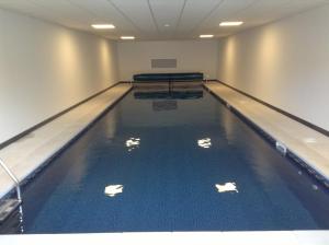 a swimming pool with blue water in a building at The Vineyard in Fowey