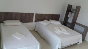 - une chambre avec 2 lits, des draps blancs et des serviettes dans l'établissement Pousada Peruíbe Ametista, à Peruíbe 24 autres photos