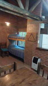 a bedroom with a bed in a brick wall at Cabañas Rio de Oro in Mina Clavero +97 photos