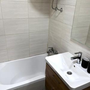 ein Badezimmer mit einer weißen Badewanne und einem Waschbecken in der Unterkunft Studio Enemia in Lesce
