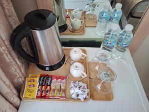 a coffee maker on a table with bottles of water at Gürses Home in Edirne