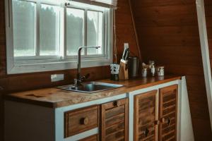 a kitchen with a sink and a window at Refúgio Fortaleza - Cabana Amora in Cambará +32 photos