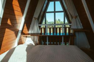 a bed in a room with a window at Refúgio Fortaleza - Cabana Amora in Cambará