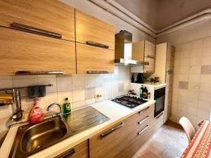 a kitchen with wooden cabinets and a stainless steel sink at Vintage Flat, Centro storico, Cagliari in Cagliari +8 photos