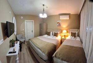 a hotel room with two beds and a tv at Gürses Home in Edirne +24 photos