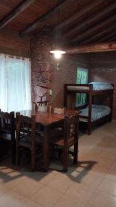 a dining room with a table and a bunk bed at Cabañas Rio de Oro in Mina Clavero