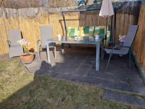 a patio with a table and chairs and an umbrella at Fewo Helga in Glowe