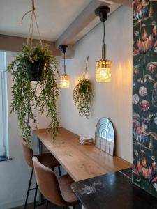 a dining room with a wooden table and pendant lights at Urban Maghin in Liège