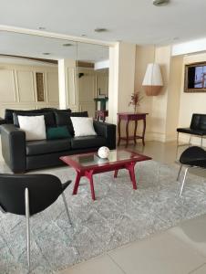 a living room with a couch and a table at Mares Apart Hotel in Mar de Ajó