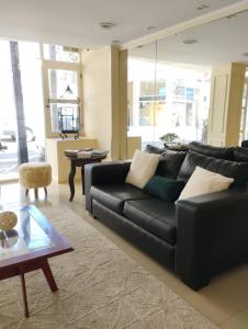 a living room with a black couch and a table at Mares Apart Hotel in Mar de Ajó