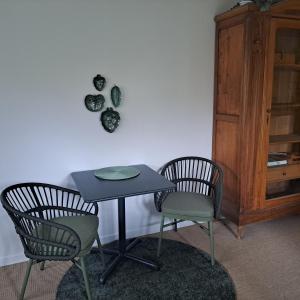 two chairs and a table with a table and a cabinet at Cute gardenhouse close to Stockholm City in Solna