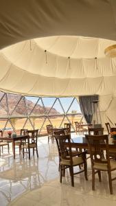 a group of tables and chairs under a tent at Lunara Desert Luxury Camp in Wadi Rum