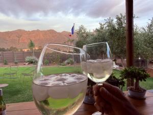 a person holding a glass of wine on a table at Glorious Stay in Porterville