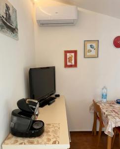 a room with a desk with a tv and a chair at Rifugio collina del Sacro Cuore in Ascoli Piceno