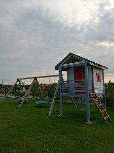 a play house with a slide in a field at Stodoły Koło Wody Niwka in Niwka